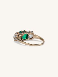 a gold ring with green and white stones