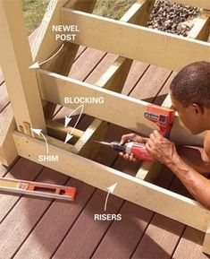 a man is using a drill to fix the bottom part of a wooden deck railing