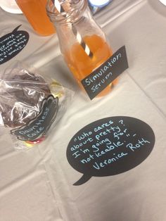 a table topped with jars filled with liquid and writing on paper next to each other