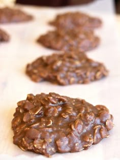 three chocolate cookies on a white surface