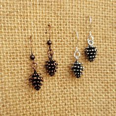 This cute and simple minimalist design features a plain, single pinecones cast from a recreation from a real pinecone. You can choose from a silver plated or copper design. The charm pendants are solid metal with good weight without being overly heavy. Each is cast in a high shine and then "antiqued" for aesthetic design. These earrings are 30 mm in drop length making them a short length on most people. A tiny tribute to Fall: a symbol of regeneration and rebirth for many folks, the acorn holds Pinecone Earrings, Vegan Jewelry, Copper Design, Stone Fox, Seed Of Life, Earrings Minimalist, Fall Jewelry, Metal Casting, Jewelry Cleaner