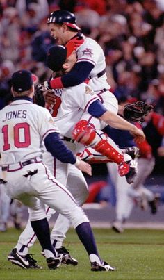 two baseball players colliding in the air during a game