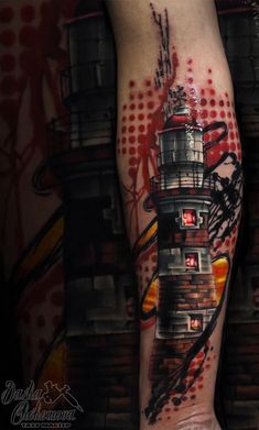 a man's leg with a lighthouse tattoo on it