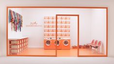 an orange and white room with two washers in it