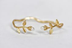 This gorgeous bracelet consists of an intricate branch with two roses with leaves growing out from each end. Each rose is decorated with a pearl, serving as the bud.  Measurements: The diameter is approximately 15cm / 6 inch. The base is adjustable and could become slightly larger or smaller for a perfect fit.    * Comes wrapped in a pretty gift packaging. * Choose between 14k gold, rose gold or silver plated brass. * you can wear it with the flowers facing up or for a more simple look you can t Gold Flower Bracelets With Rose Design, Adjustable Rose Gold Flower Bracelets, Spring Rose Gold Flower Bracelet, Elegant Flower Cuff Bracelet, Elegant Gold Flower Cuff Bracelet, Elegant Flower Shaped Cuff Bracelet, Dainty Rose Gold Flower-shaped Bracelets, Adjustable Rose Gold Flower-shaped Bracelet, Elegant Flower-shaped Cuff Bracelet