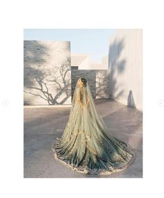 a woman in a wedding dress is standing outside