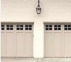 two white garage doors with one light on the side