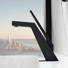 a faucet in front of a window with a view of the city below