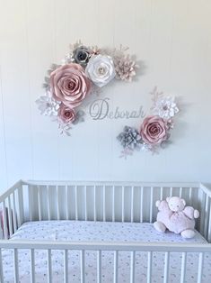 a baby crib with flowers and a teddy bear