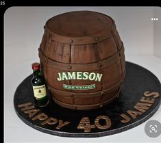 a birthday cake made to look like a barrel with a bottle of jameson on top