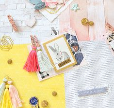 a table topped with lots of different types of paper and crafting supplies next to a brick wall