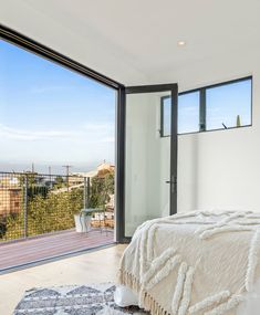 a bedroom with a large glass window overlooking the city