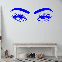 an eye wall decal with blue lashes and eyelashes in the middle, on a white wall