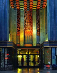 the entrance to a large building lit up at night with bright lights on it's sides