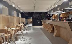 an empty restaurant with tables and chairs lined up against the wall, along with chalkboards on the walls