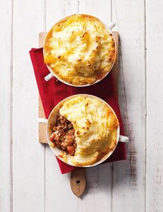 two bowls filled with food sitting on top of a red napkin