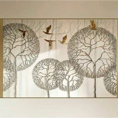 three birds are flying over the trees in this modern art piece, which is mounted on a wall