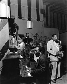 a black and white photo of men playing instruments