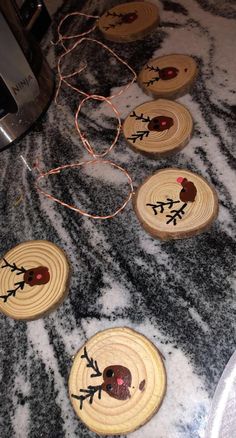 four wooden slices with designs on them sitting on a counter