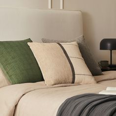 a bed with two pillows and some books on the headboard in front of it