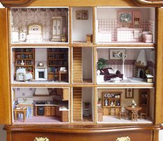 a doll house with furniture and accessories in it's wooden display case on top of a dresser