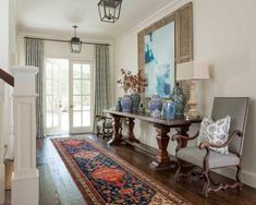 a living room filled with furniture and a large rug on top of a hard wood floor