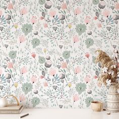 a white table topped with a vase filled with flowers next to a wallpapered wall