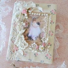 an altered photo frame with lace and flowers on the edge, next to a key