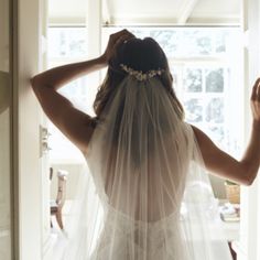 the back of a bride's wedding dress, with her veil draped over her head