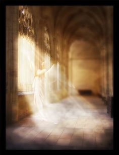 a woman standing in an empty room with sunlight coming through the window and her arms stretched out