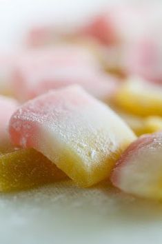 several different colored candies on a white surface