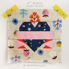 the block is made up of fabric and has a heart shaped patch on top of it