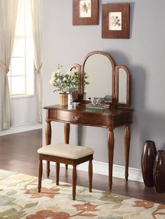 a wooden vanity table with a mirror and stool in front of it on top of a rug