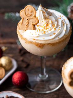 a drink with whipped cream and ginger cookies on top, next to other christmas decorations