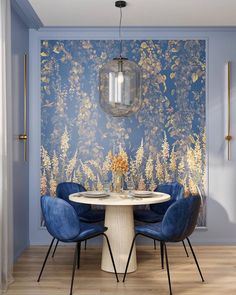 a dining room with blue chairs and a wallpapered background that has gold flowers on it