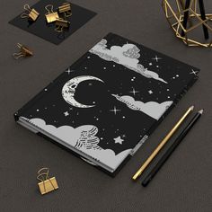 a black and white notebook sitting on top of a table next to some gold objects