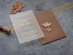 the wedding stationery is laid out on the table with coins and other items around it