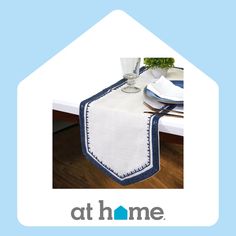 a blue and white table runner on top of a dining room table with the words at home above it