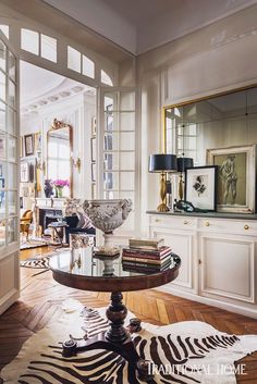 a living room filled with furniture and lots of mirrors on top of the wall next to a doorway