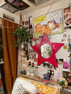 a room with posters and pictures on the wall, including a star hanging from a ceiling