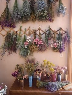 a bunch of flowers that are sitting on a table next to a wall mounted planter