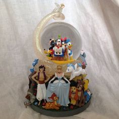 there is a glass figurine on top of a stand with many different figures