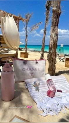 the beach is covered with white towels and chanel bags, sunglasses, perfume bottles, and other items