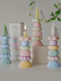 there are many different colored candles on the table