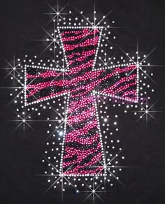 a cross made out of pink and white beads on a black shirt with stars around it