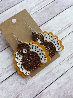 brown and white earrings with polka dots on them