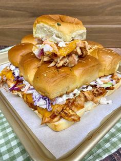 two sandwiches stacked on top of each other with coleslaw and chicken in the middle