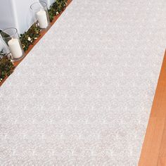 a white rug sitting on top of a wooden floor next to a table and chairs