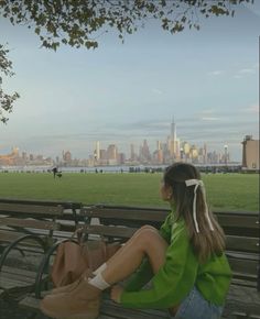 a woman sitting on top of a wooden bench