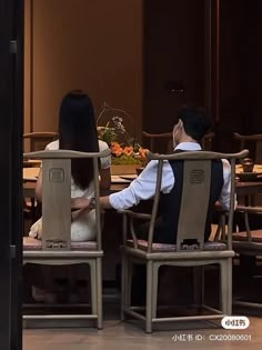 two people sitting in chairs facing each other